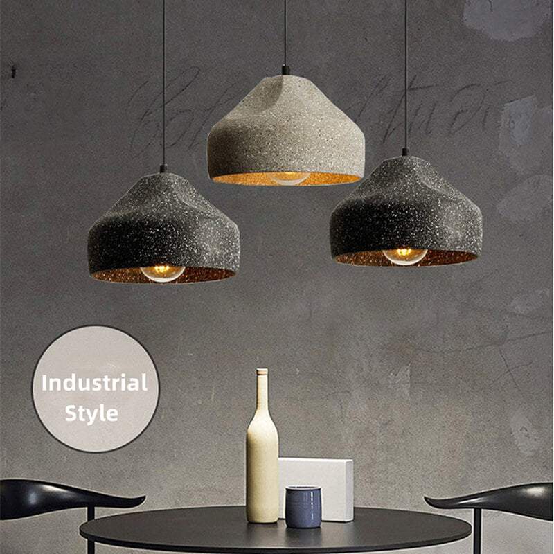 Industrial-style concrete pendant lights hanging over a kitchen island, showcasing minimalist design and modern elegance in a Nordic cement finish.
