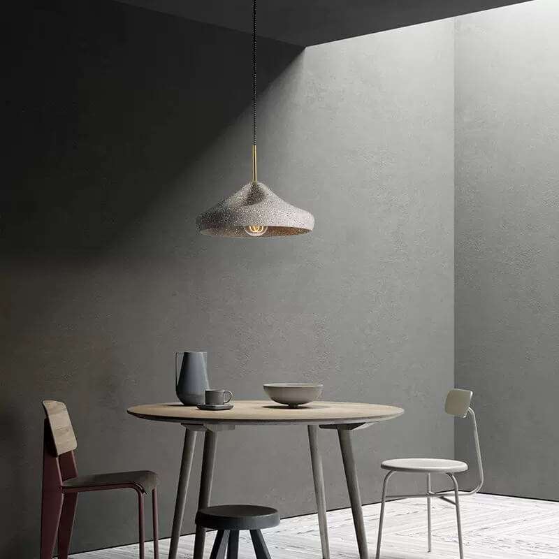 Industrial-style concrete pendant lights hanging over a kitchen island, showcasing minimalist design and modern elegance in a Nordic cement finish.