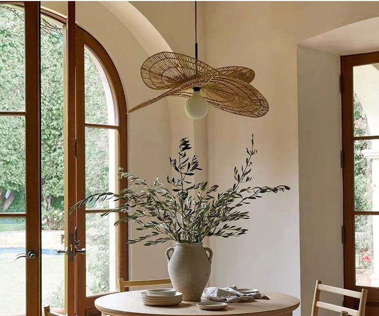 Wabi-Sabi pendant light with double-layered rattan design hanging above a dining table in a rustic interior setting.
