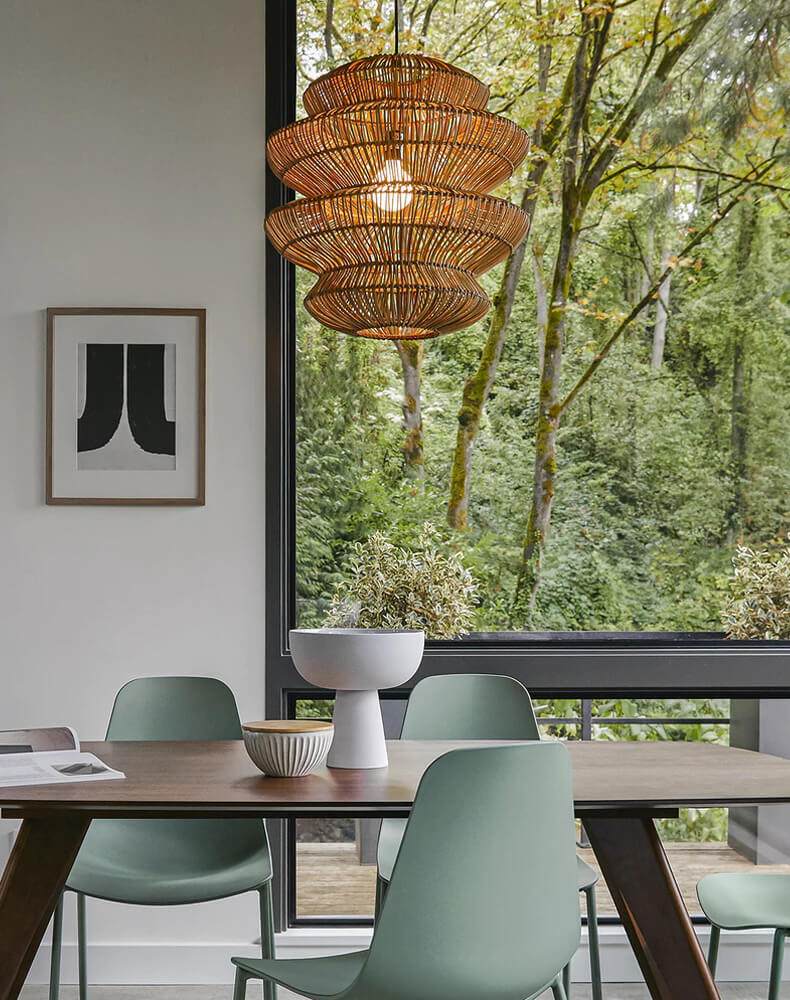 Boho rattan lamp hanging over kitchen island with elegant dining setup.