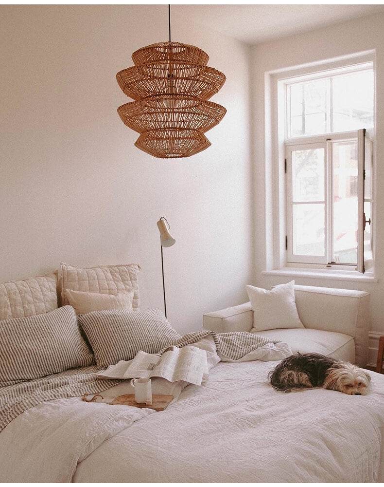 Boho rattan lamp hanging in a cozy bedroom with natural light.
