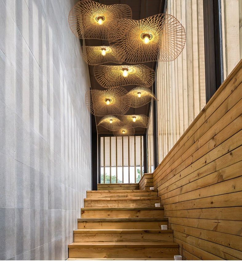 Handcrafted bamboo hallway pendant light illuminating a wooden staircase with natural elegance.