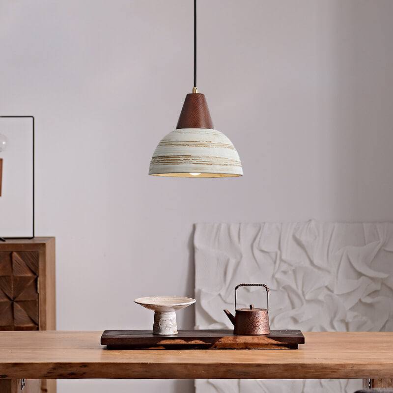 Handmade ceramic pendant light with wooden accents, featuring a minimalist design ideal for modern interiors.