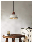 Handmade ceramic pendant light with wooden accents, featuring a minimalist design ideal for modern interiors.