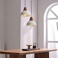 Handmade ceramic pendant light with wooden accents, featuring a minimalist design ideal for modern interiors.