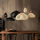 Southeast Asian vintage rattan pendant lights hanging over a rustic dining table.