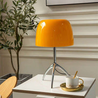 Italian tripod desk lamp with glass shade on minimalist base, ideal for modern interiors.