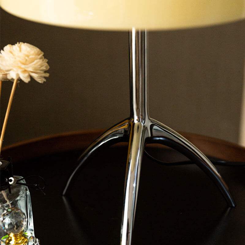 Italian tripod desk lamp with glass shade on minimalist base, ideal for modern interiors.