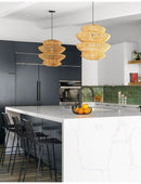 Boho rattan lamp hanging above a modern kitchen island with marble countertop.