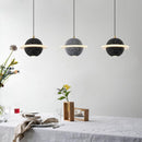 Modern LED cement pendant lamp with Nordic design over dining table.