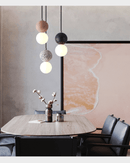 Nordic cement pendant lights hanging over dining table with modern decor in background.