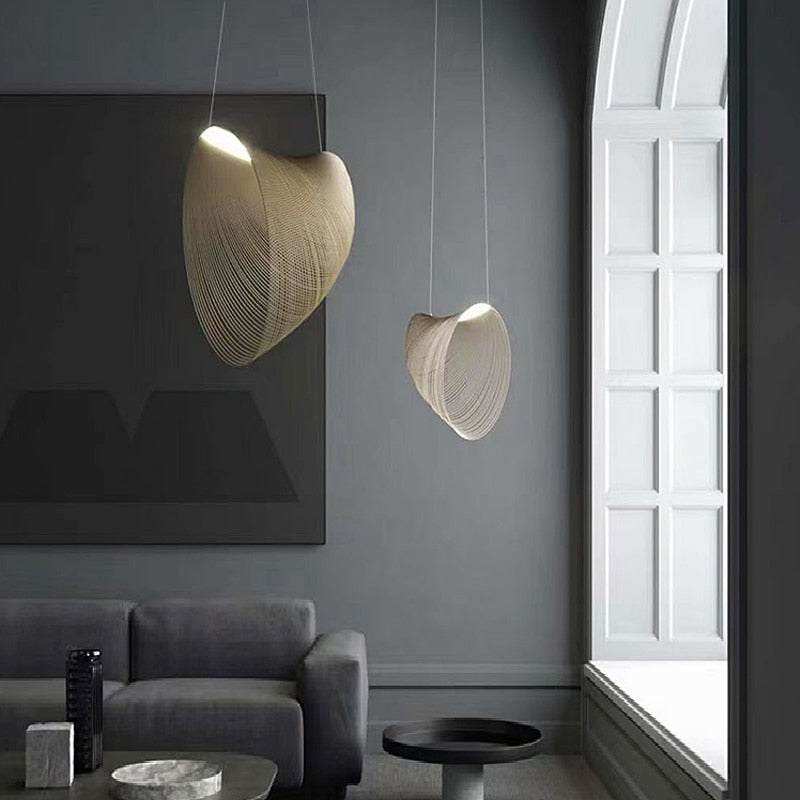 Nordic wood pendant light with snail-shaped design, LED lighting, in a modern living room setting.